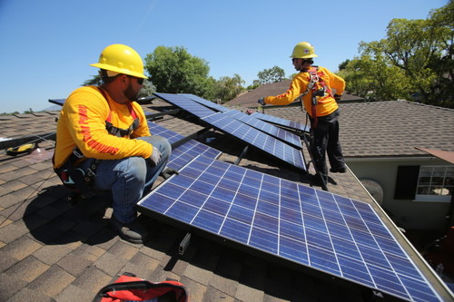 Sullivan Solar Power employees install solar panels on the roof of a San Diego home. 