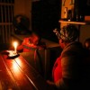  A woman runs her takeaway restaurant by candlelight during a scheduled power outage in the impoverished neighbourhood of Masiphumelele, Cape Town